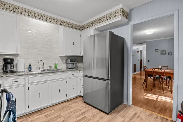 a kitchen with stainless steel appliances granite countertop a sink and cabinets with wooden floor