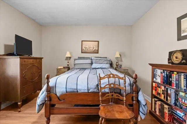 a bedroom with a bed and a flat tv screen on dresser