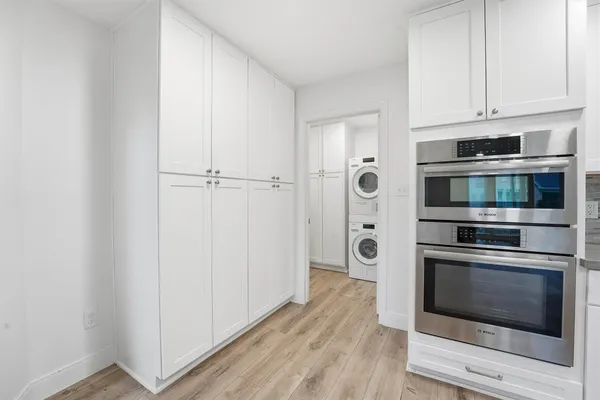 a kitchen with stainless steel appliances white cabinets and wooden floors