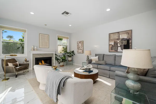 a living room with furniture a flat screen tv and a floor to ceiling window