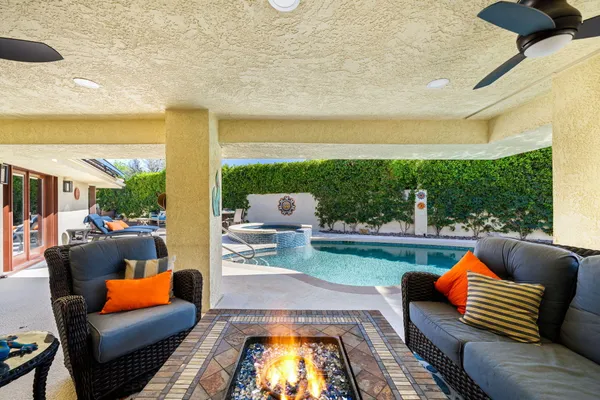 a view of a patio with couches table and chairs and potted plants