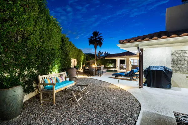 a view of a backyard with table and chairs under an umbrella
