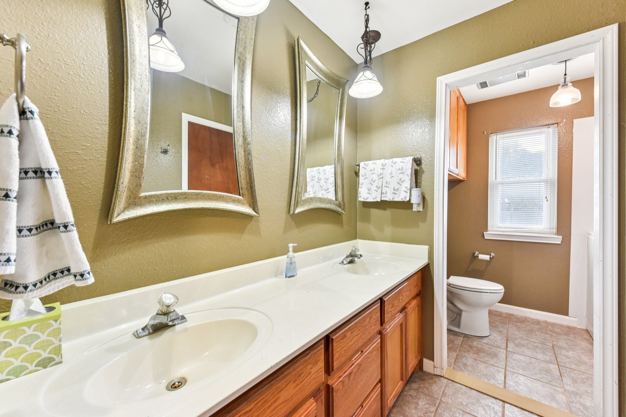 504 Buckaroo Trail Buda, TX 78610 - Photo 14 of 39 Bathroom featuring double vanity, light tile patterned flooring, and a textured wall