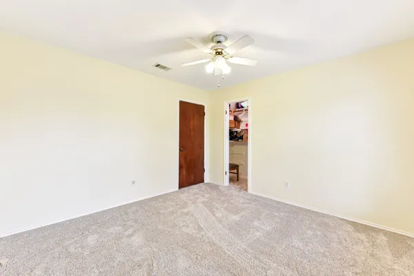 an empty room with a ceiling fan and a window