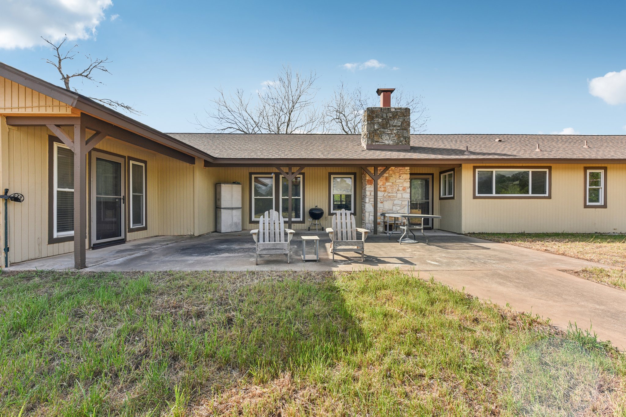 504 Buckaroo Trail Buda, TX 78610 - Photo 22 of 39 Rear view of property featuring a chimney, a patio area, roof with shingles, and a lawn