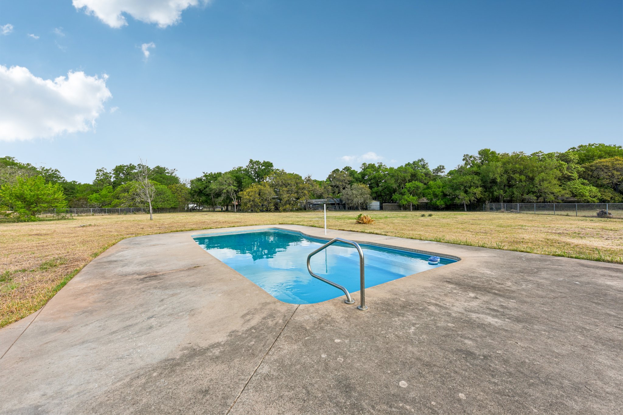 504 Buckaroo Trail Buda, TX 78610 - Photo 24 of 39 Outdoor pool with a patio and view of scattered trees