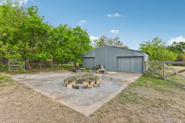 a backyard of a house with table and chairs with wooden fence