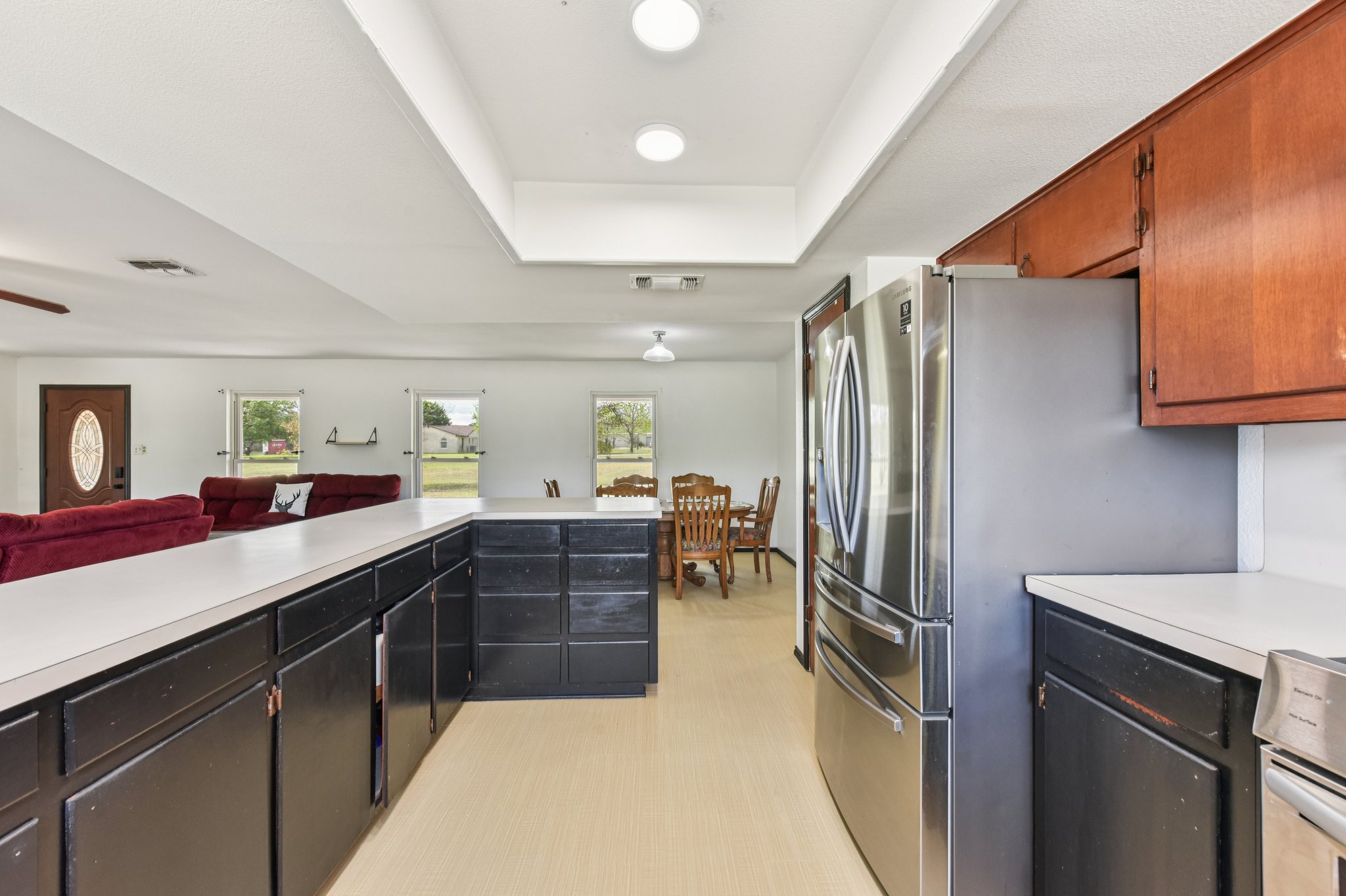 504 Buckaroo Trail Buda, TX 78610 - Photo 39 of 39 Kitchen with light countertops, a tray ceiling, freestanding refrigerator, and open floor plan