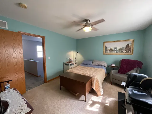 a spacious bedroom with a bed and a chandelier