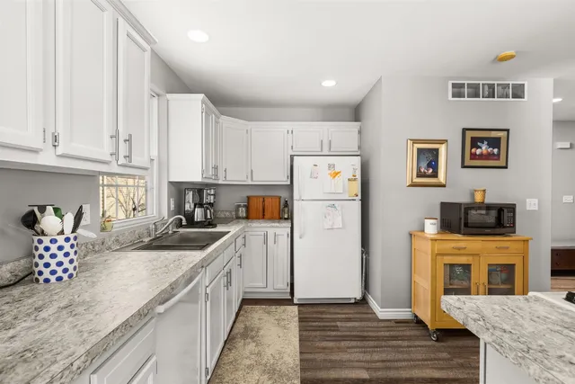 a kitchen with a refrigerator sink and cabinets