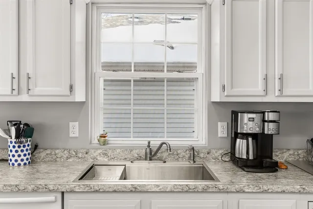 a kitchen sink with a window and cabinets