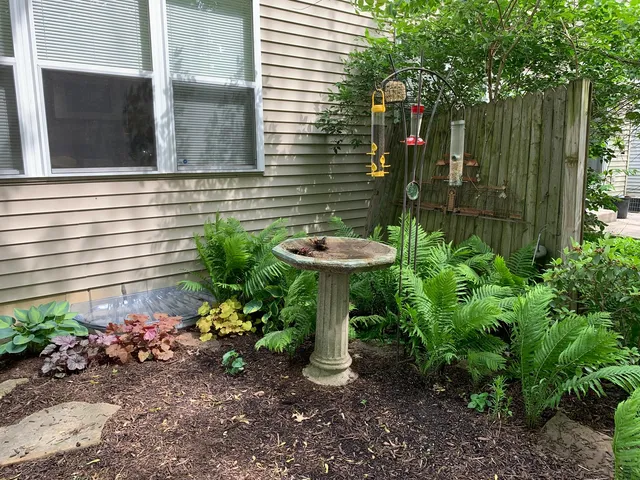 a view of a backyard with plants and brick wall