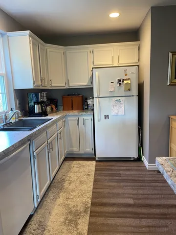 a kitchen with white cabinets and refrigerator