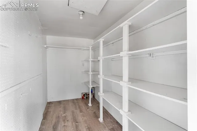 a view of a hallway with wooden floor and cabinet