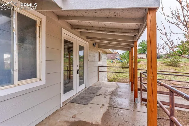 a large room with chandelier fan and windows