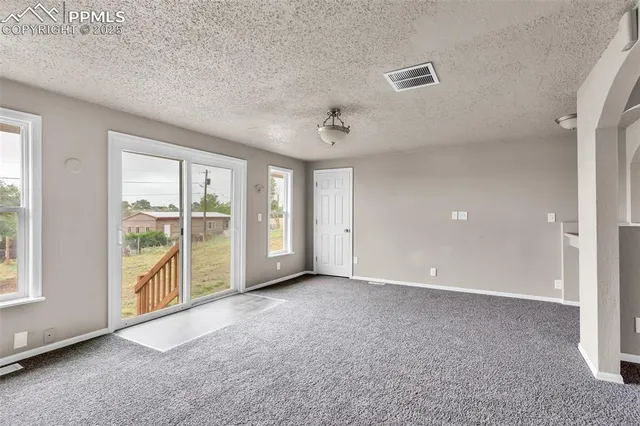 a view of an empty room with a kitchen