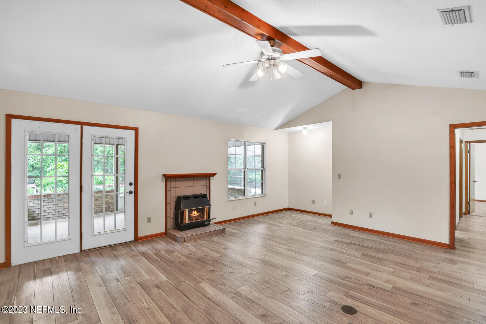4250 Banks Road Middleburg, FL 32068 - Photo 33 of 48 an empty room with wooden floor fireplace and windows