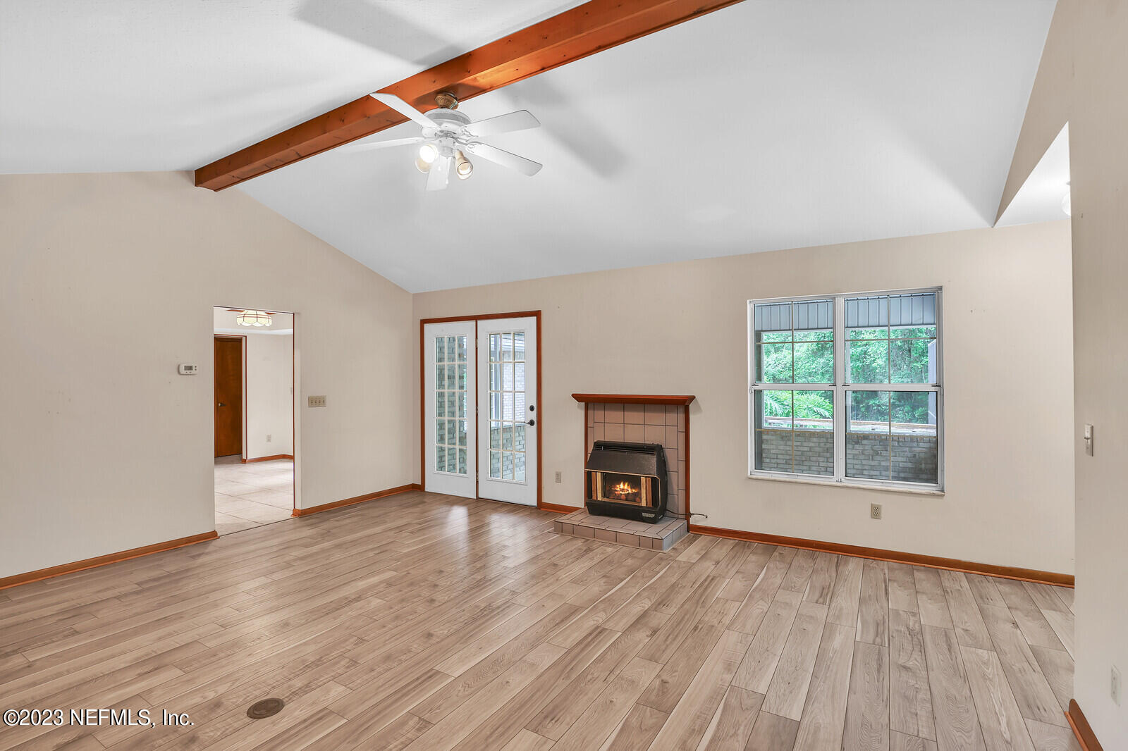 4250 Banks Road Middleburg, FL 32068 - Photo 35 of 48 an empty room with wooden floor a fireplace and windows