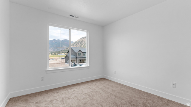 4170 North 560th West, Unit 6 Tooele, UT 84074 - Photo 19 of 20 Bright interior space featuring a large window, neutral wall paint, white trim, and a textured carpet