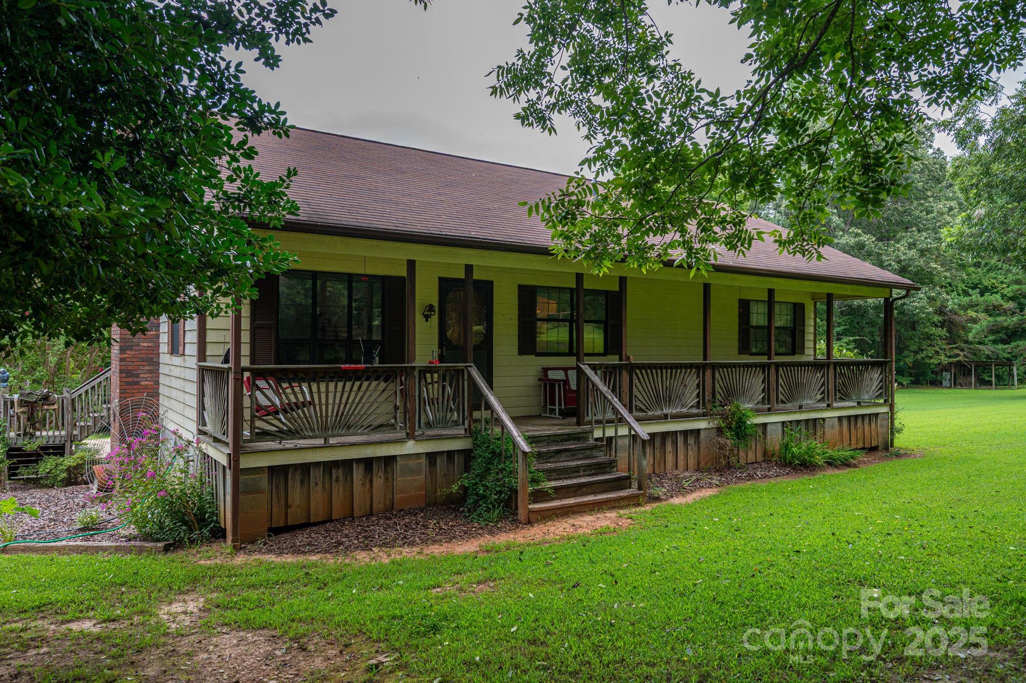 a view of house with a yard and potted plants