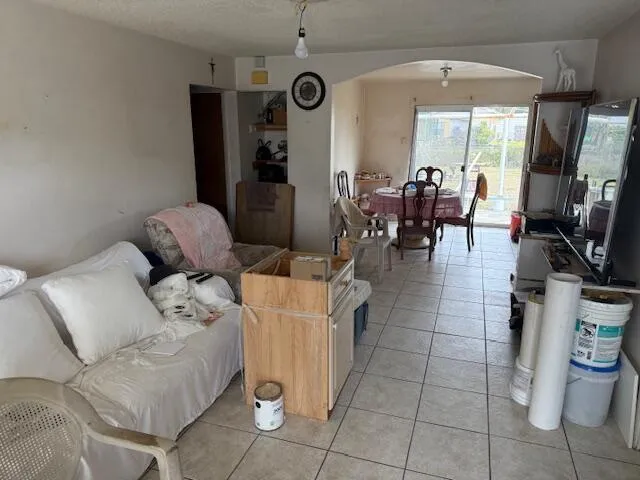 a living room with furniture a flat screen tv and gym equipment