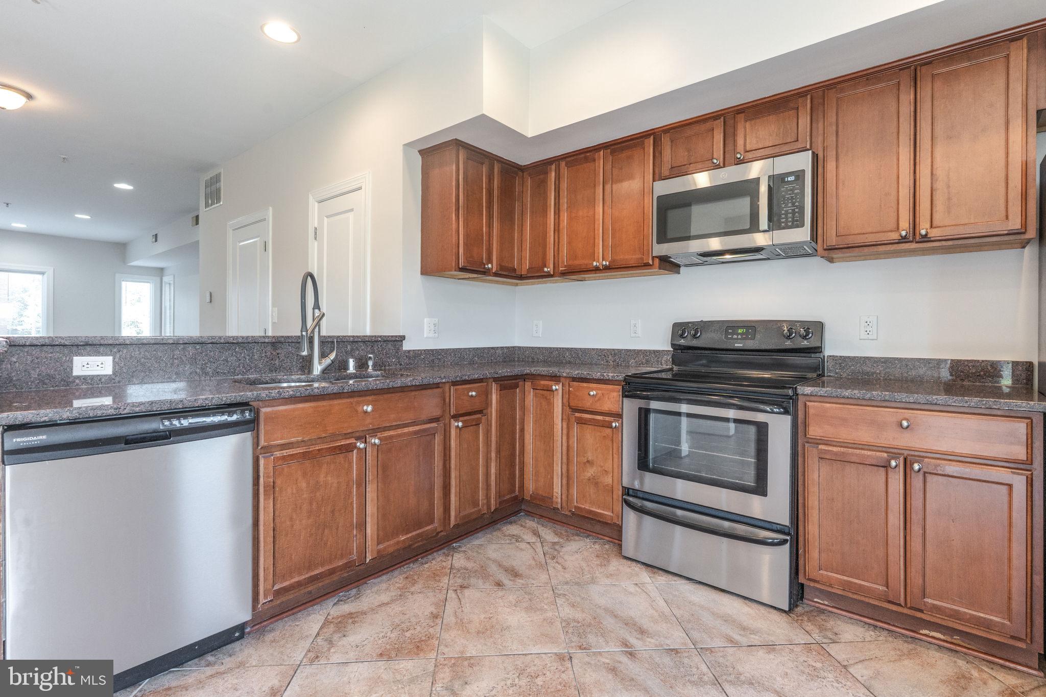 1384 Talbert Court Southeast, Unit A Washington, DC 20020 - Photo 15 of 35 a kitchen with stainless steel appliances granite countertop a sink stove and microwave