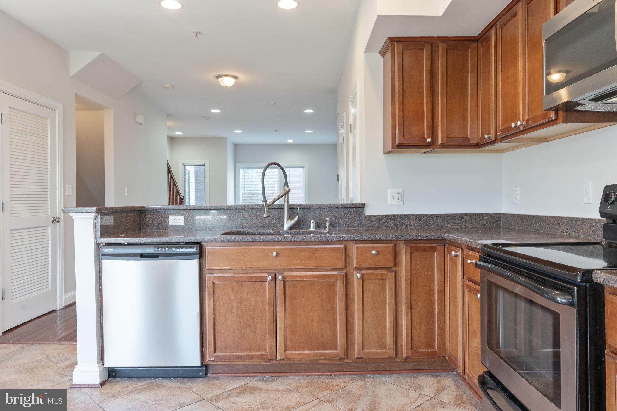 1384 Talbert Court Southeast, Unit A Washington, DC 20020 - Photo 16 of 35 a kitchen with stainless steel appliances granite countertop a sink stove and cabinets