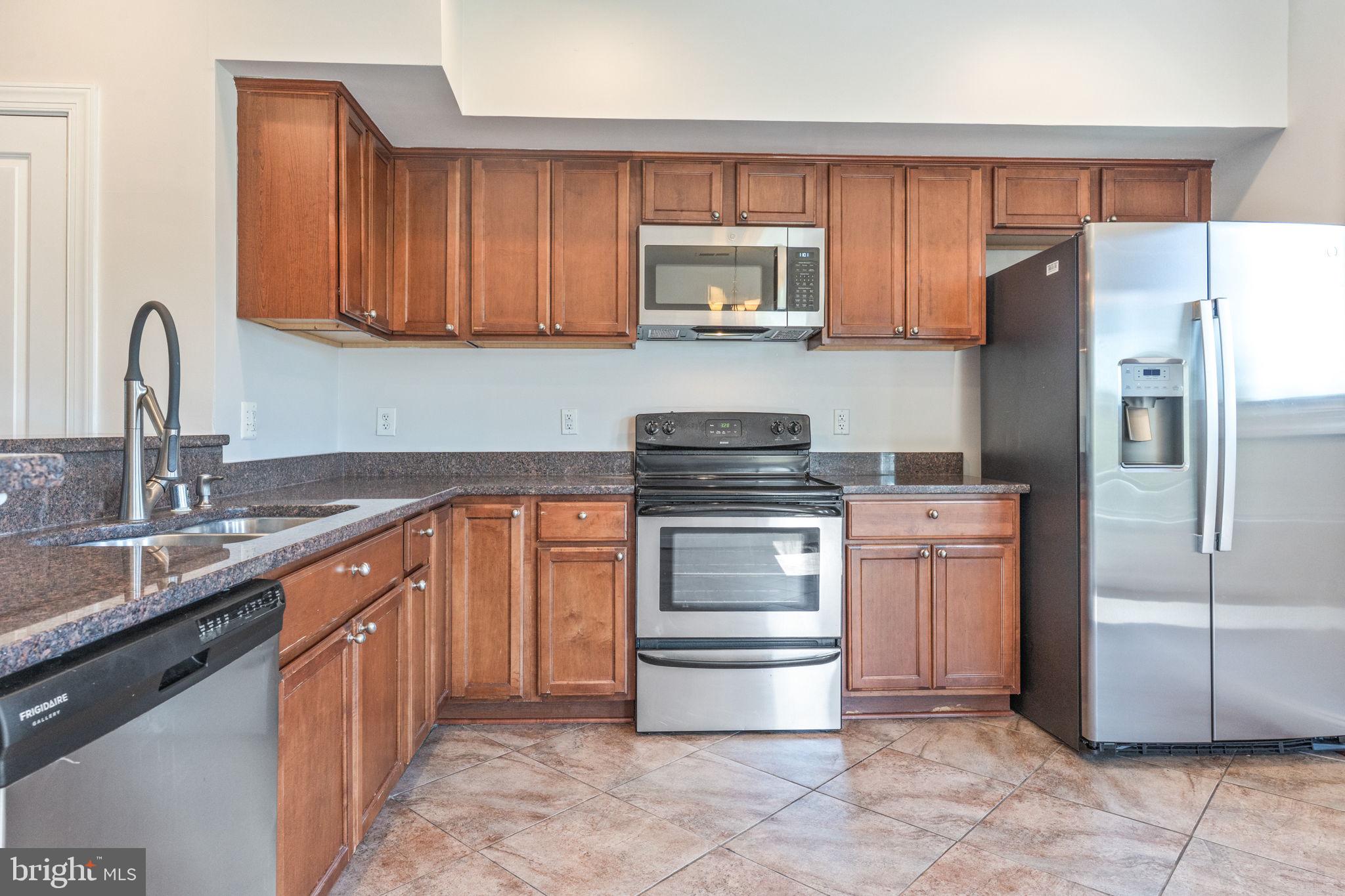 1384 Talbert Court Southeast, Unit A Washington, DC 20020 - Photo 17 of 35 a kitchen with a refrigerator sink and cabinets