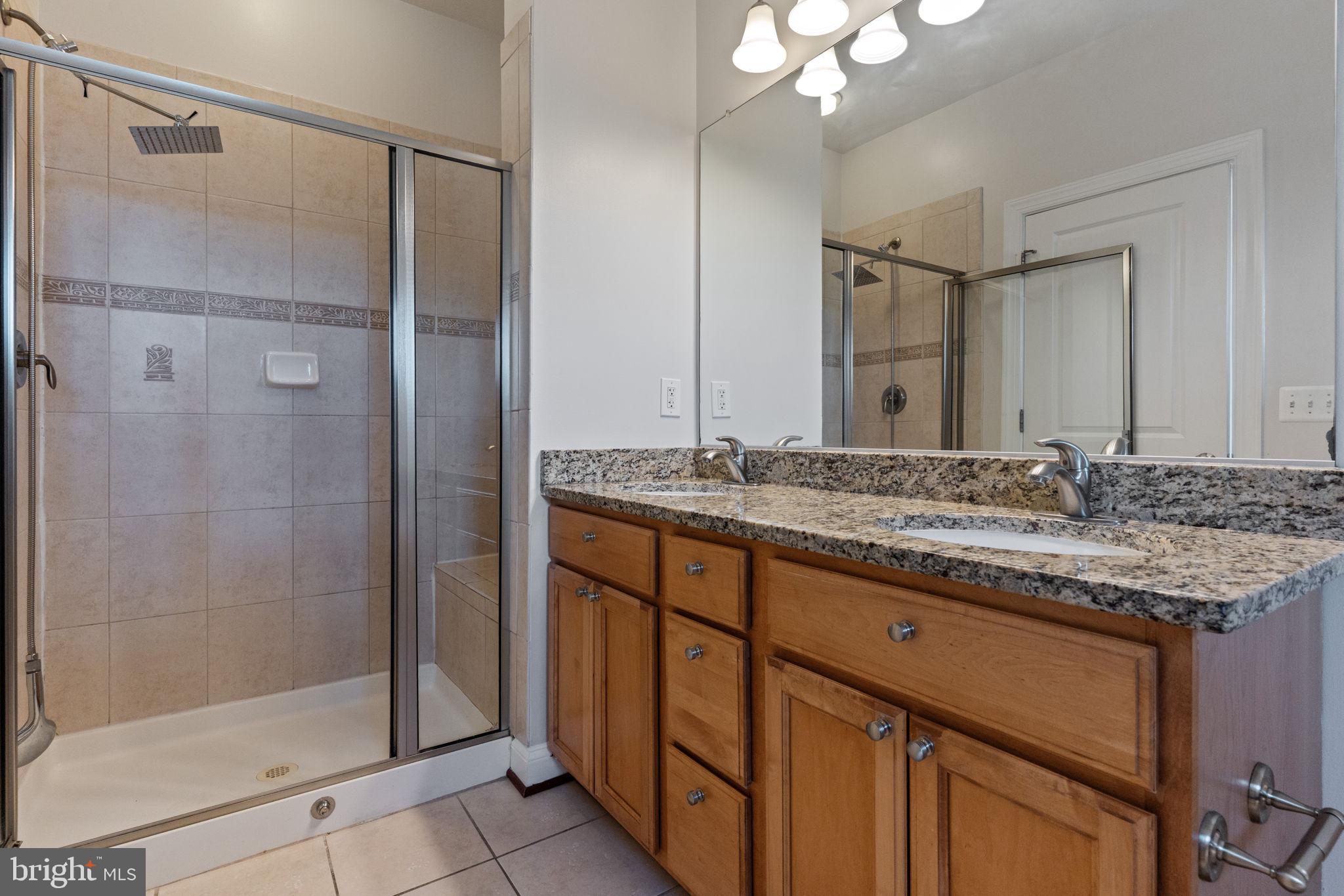 1384 Talbert Court Southeast, Unit A Washington, DC 20020 - Photo 27 of 35 a bathroom with a granite countertop sink a mirror and a shower