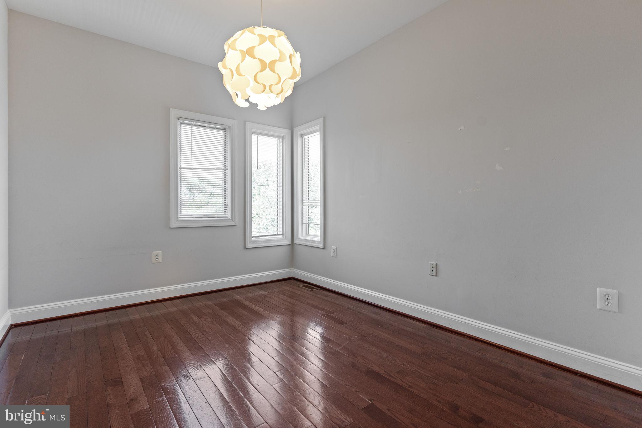 1384 Talbert Court Southeast, Unit A Washington, DC 20020 - Photo 30 of 35 an empty room with wooden floor and windows