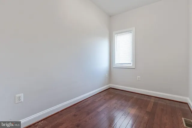 a view of a small space with wooden floor and a window
