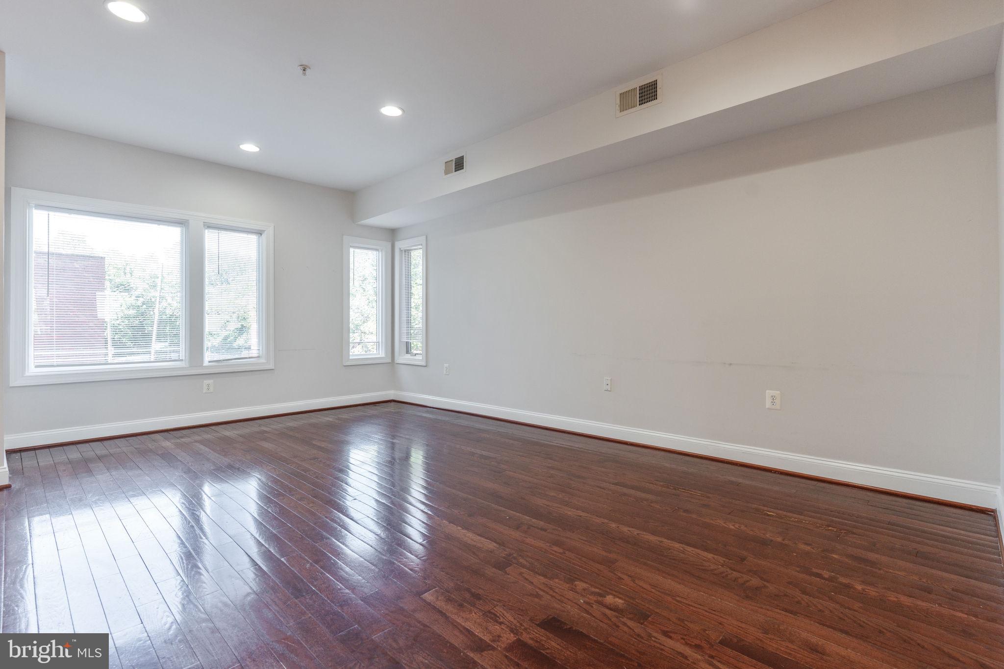1384 Talbert Court Southeast, Unit A Washington, DC 20020 - Photo 5 of 35 a view of an empty room with wooden floor and window