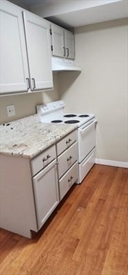 1 Samoset Avenue, Unit WINTER Mansfield, MA 02048 - Photo 2 of 7 a kitchen with granite countertop white cabinets and white appliances