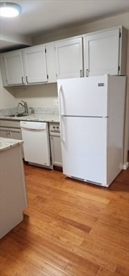 1 Samoset Avenue, Unit WINTER Mansfield, MA 02048 - Photo 3 of 7 a kitchen with wooden cabinets and white stainless steel appliances