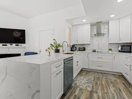 a kitchen with kitchen island white cabinets and white appliances