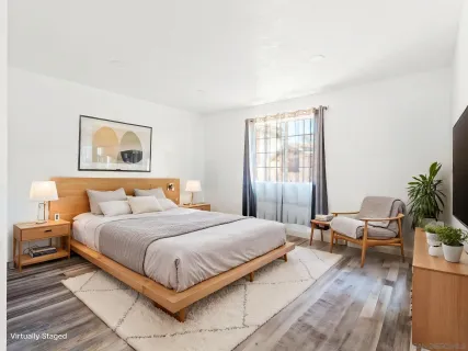 a bedroom with a large bed and a potted plant