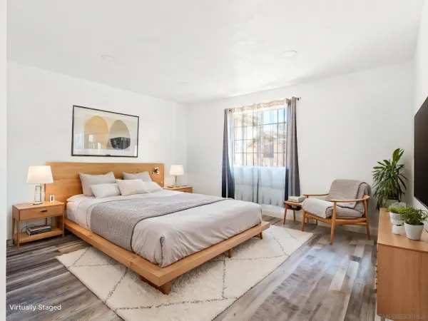 a bedroom with a large bed and a potted plant