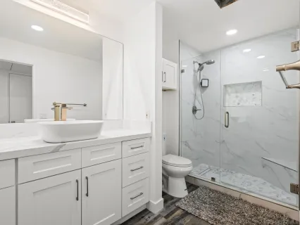 a bathroom with a sink a toilet and shower