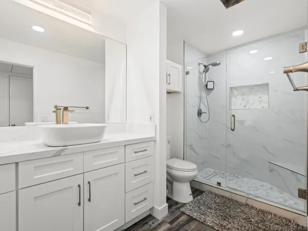 a bathroom with a sink a toilet and shower