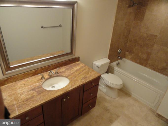 1237 Kenyon Street Northwest, Unit A Washington, DC 20010 - Photo 4 of 6 a bathroom with a granite countertop sink toilet and shower