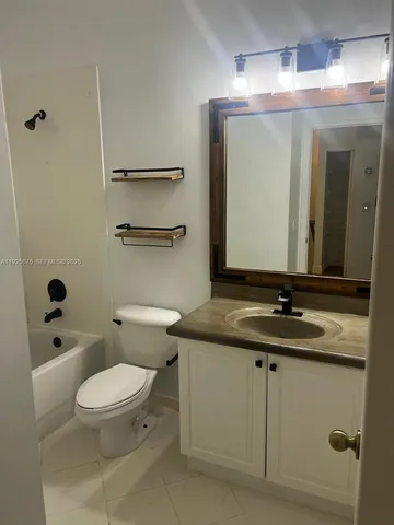 a bathroom with a granite countertop sink a toilet and a mirror