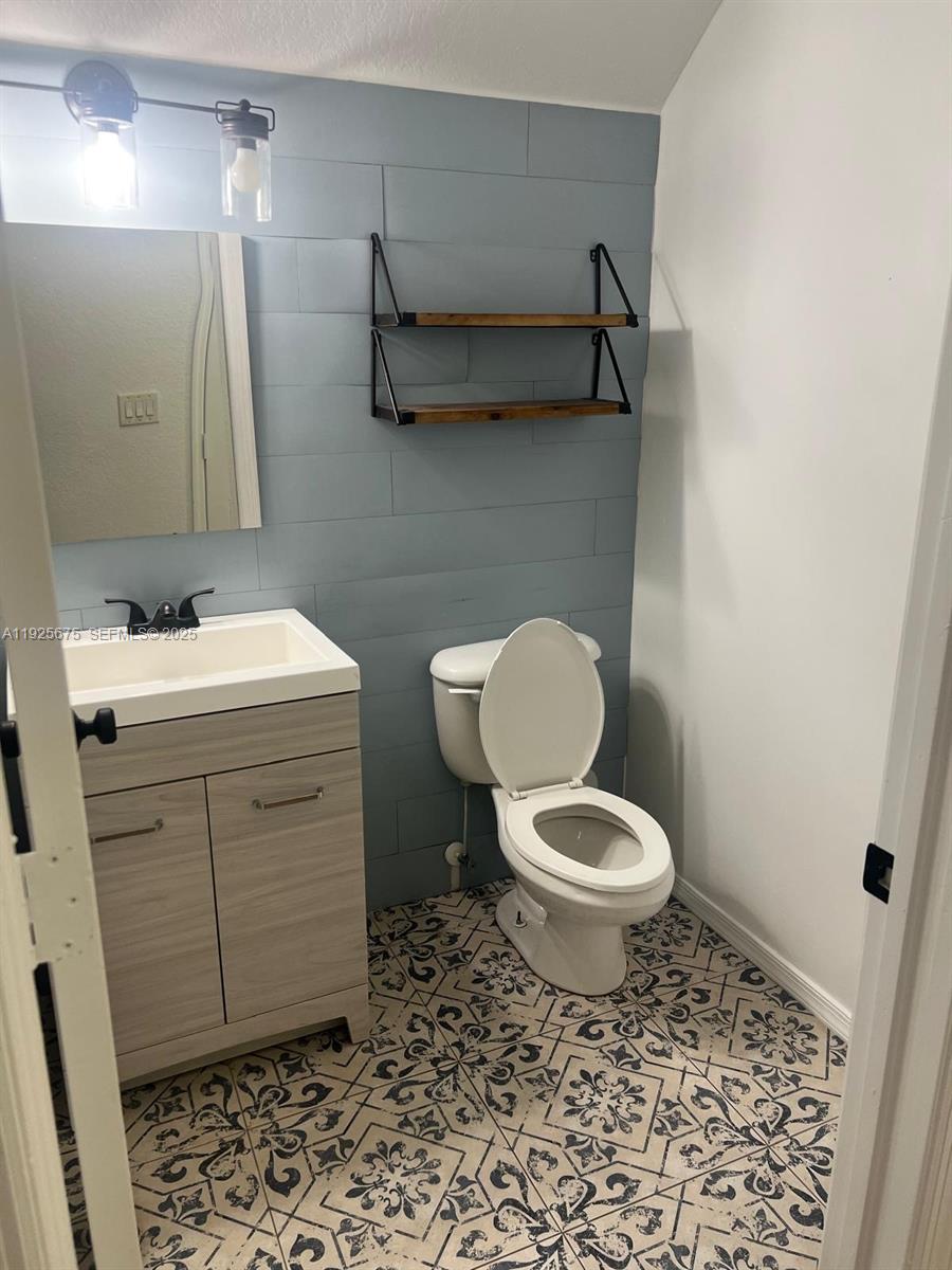 11467 Southwest 238th Street Homestead, FL 33032 - Photo 2 of 16 a bathroom with a toilet a sink and mirror