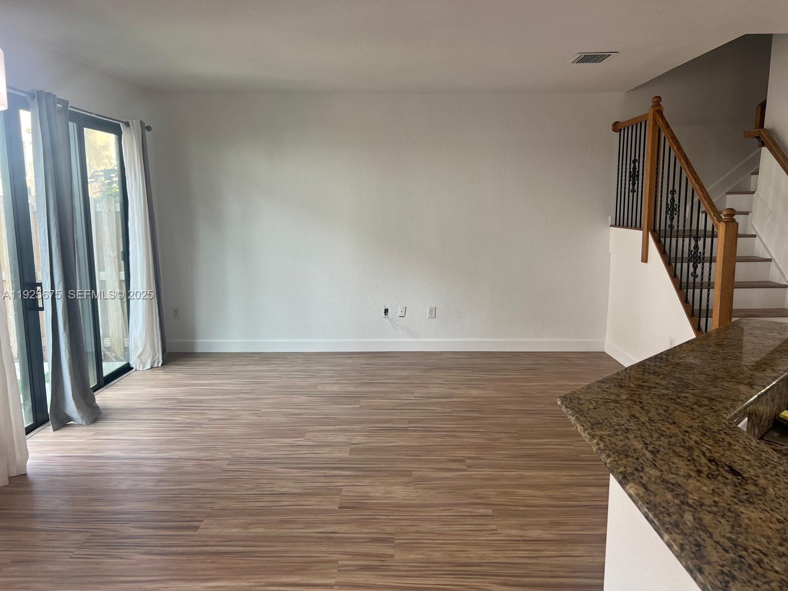 11467 Southwest 238th Street Homestead, FL 33032 - Photo 5 of 16 a view of a room with wooden floor and stairs