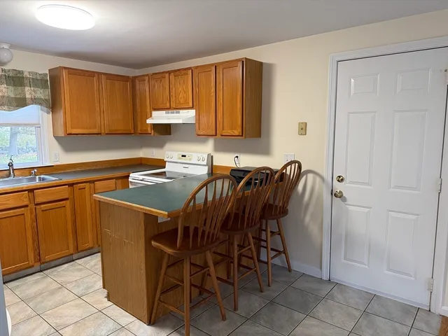 a kitchen with a table chairs refrigerator and microwave