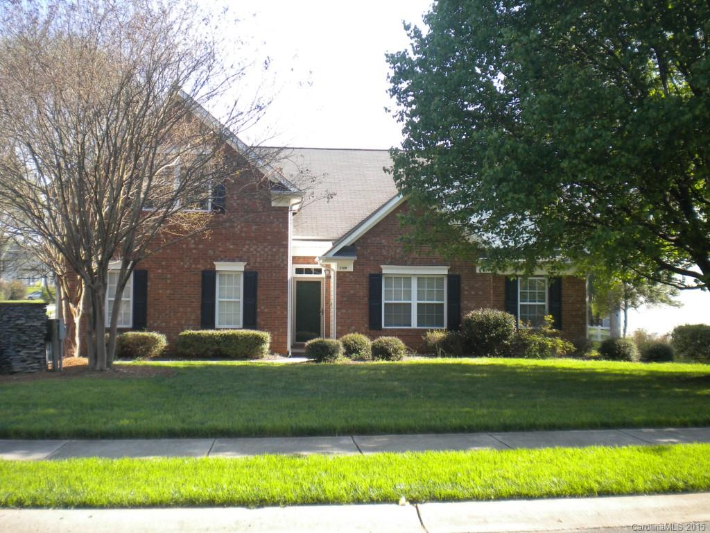 a front view of a house with a garden and trees