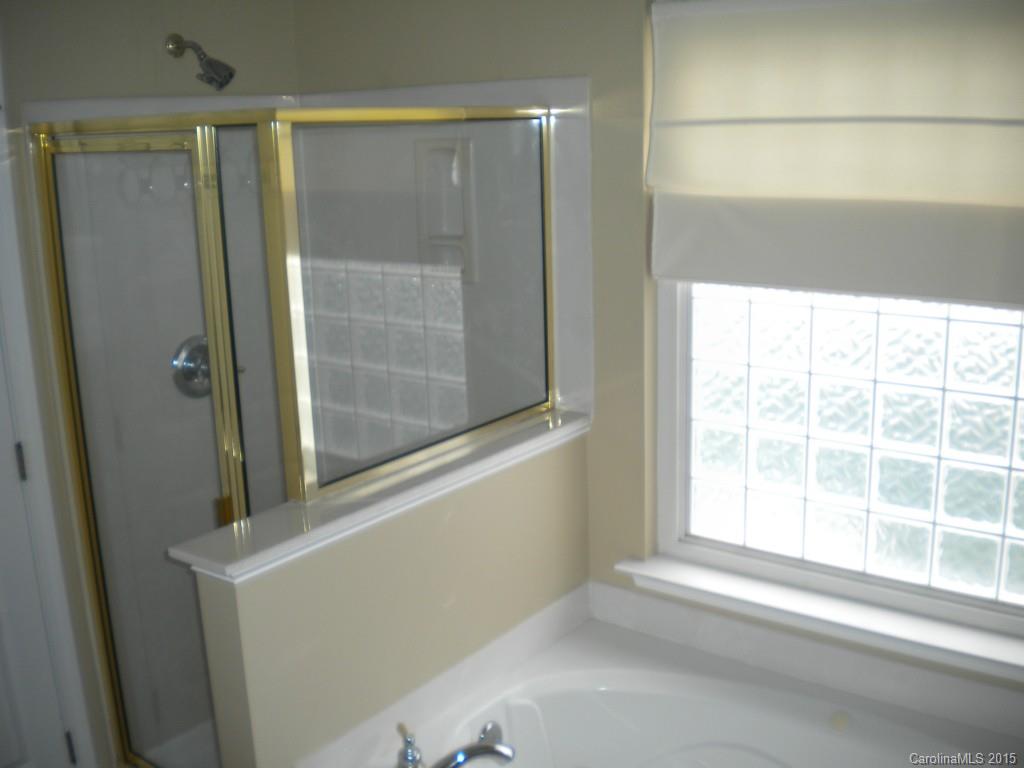 2309 Hargett Road Matthews, NC 28105 - Photo 18 of 24 a view of a bathroom with a glass door and a window