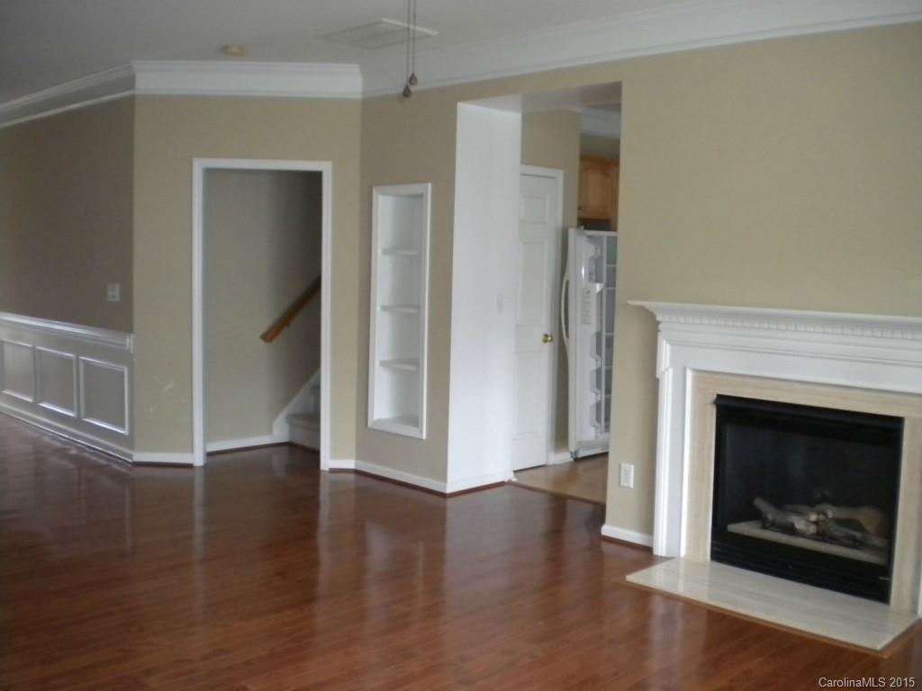 2309 Hargett Road Matthews, NC 28105 - Photo 6 of 24 a view of an empty room with wooden floor fireplace and a window