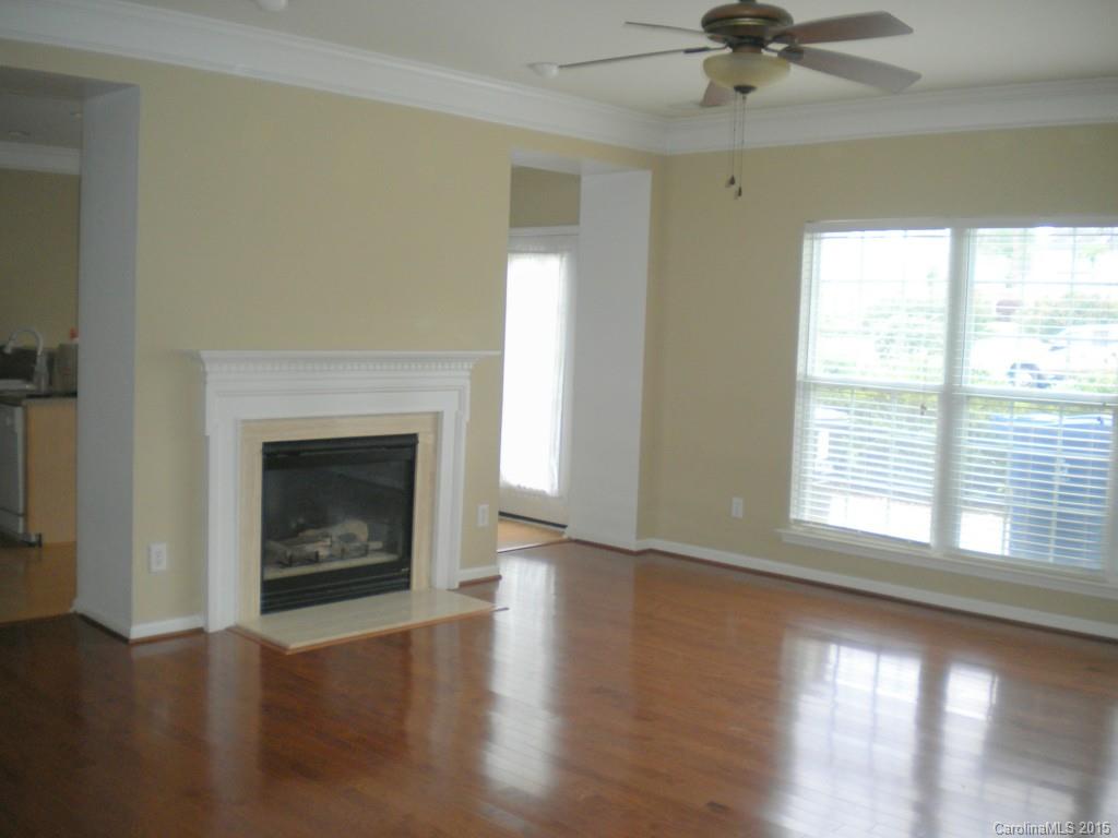 2309 Hargett Road Matthews, NC 28105 - Photo 7 of 24 a view of an empty room with wooden floor fireplace and a window