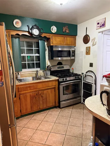 a kitchen with granite countertop a stove a sink and a microwave