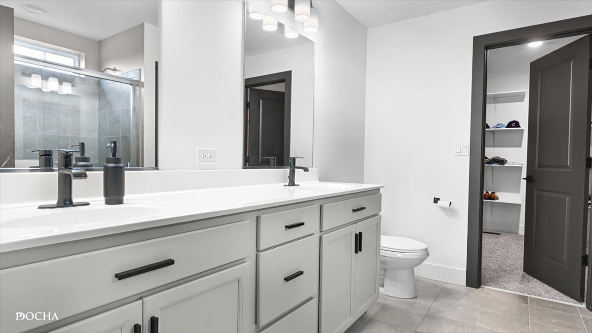 26827 Ashgate Crossing Plainfield, IL 60585 - Photo 11 of 31 a bathroom with a double vanity sink a toilet and a mirror